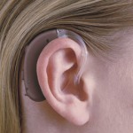 昔ながらの耳掛け型補聴器を付けている写真