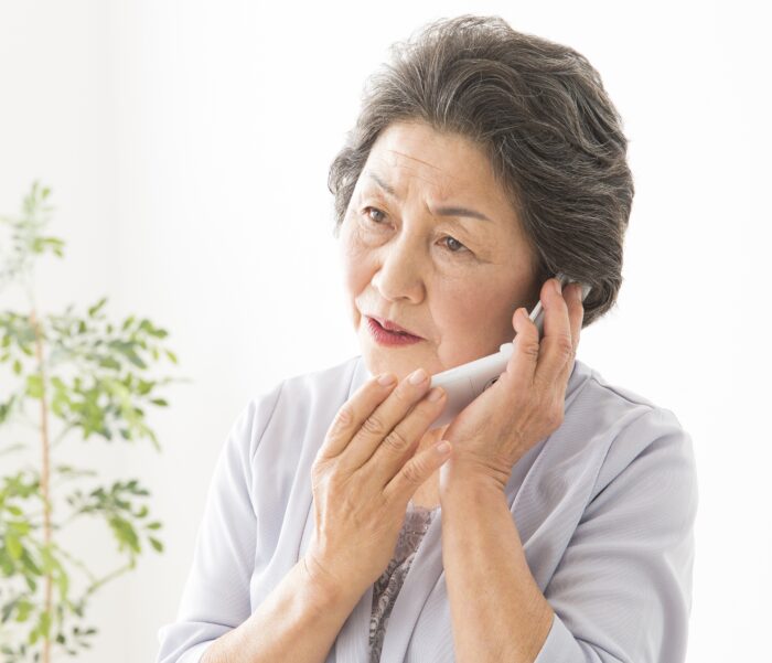 電話で重要な話をするシニア女性